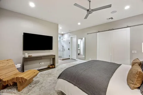 a bedroom with a bed and a flat screen tv
