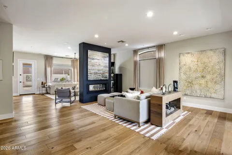 a living room with fireplace furniture and a large window