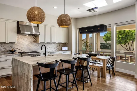 a kitchen with stainless steel appliances granite countertop a sink a stove and a wooden floors