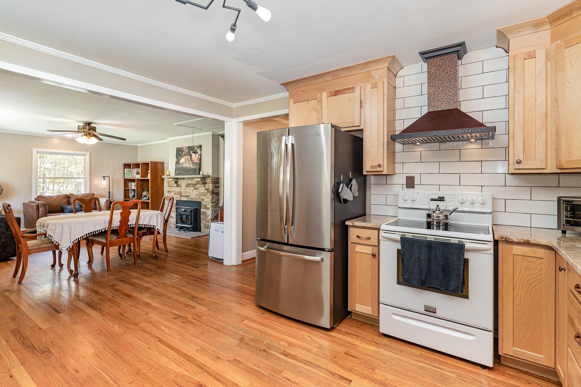 1029 Cumberland Heights Road Clarksville, TN 37040 - Photo 4 of 34 a kitchen with stainless steel appliances granite countertop a refrigerator a stove a sink a dining table and chairs with wooden floor