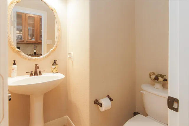 a bathroom with a sink and mirror with toilet