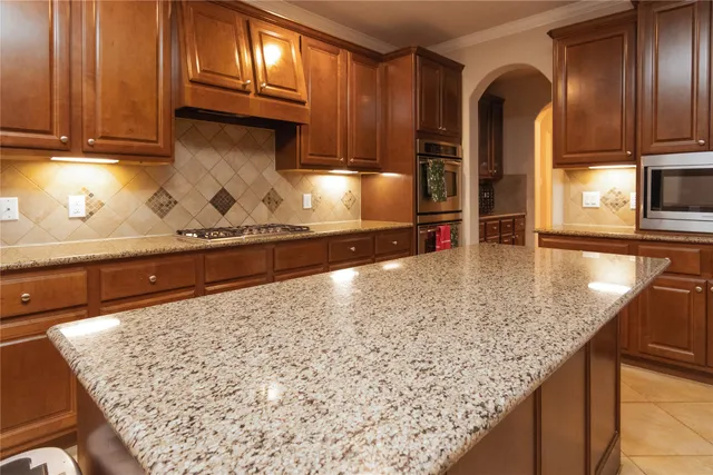a kitchen with stainless steel appliances granite countertop a sink stove and cabinets