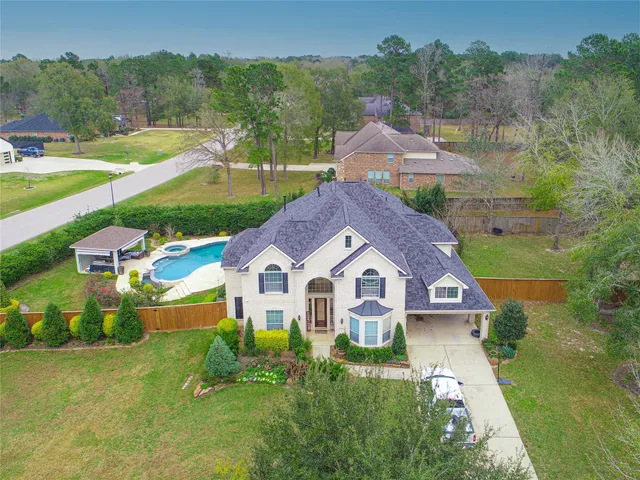 an aerial view of residential houses with outdoor space and trees