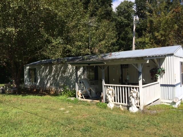 Covered porch with a tidy and charming mobile home