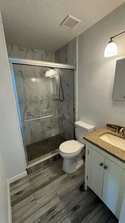 a bathroom with a sink a toilet and shower