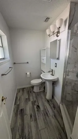 a bathroom with a sink toilet and shower