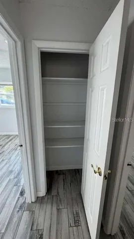 a view of walk in closet with wooden floor