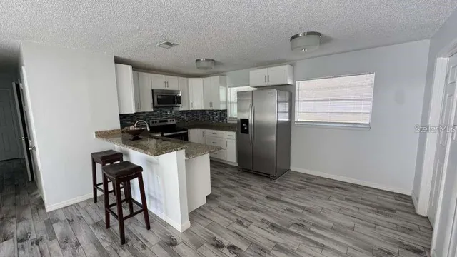 a kitchen with a refrigerator a stove top oven a sink and dishwasher