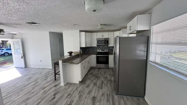 a kitchen with stainless steel appliances a refrigerator stove and wooden floor