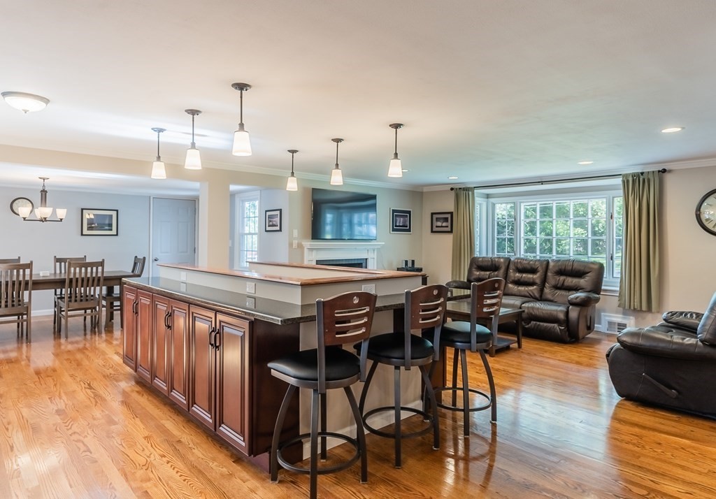2 East Colonial Road Wilbraham, MA 01095 - Photo 12 of 42 a kitchen with stainless steel appliances granite countertop a stove a refrigerator a dining table and chairs with wooden floor