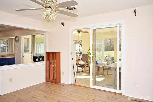 a view of a livingroom with wooden floor and a ceiling fan