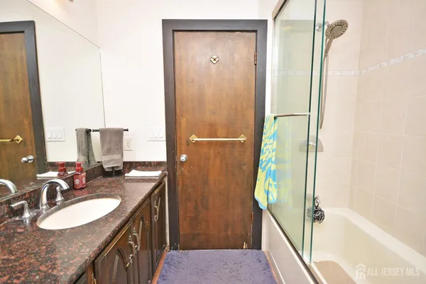 a bathroom with a granite countertop sink and a mirror