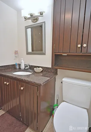 a bathroom with a granite countertop toilet sink and mirror