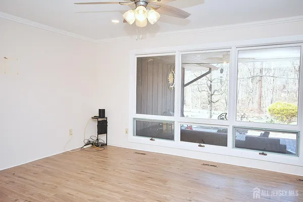 en empty room with a large window and chandelier