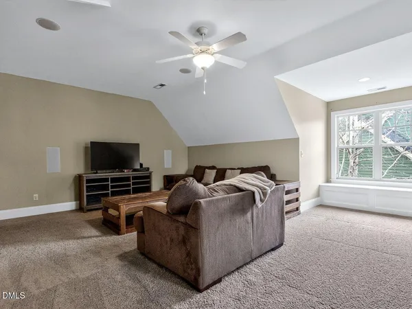 a view of a hallway to room with wooden floor and furniture