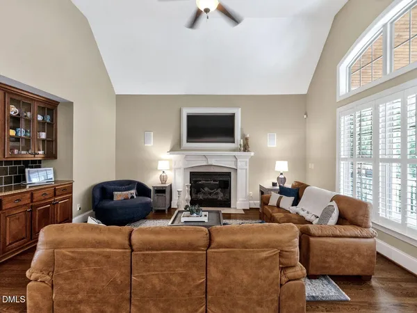 a living room with furniture a rug a fireplace and a flat screen tv
