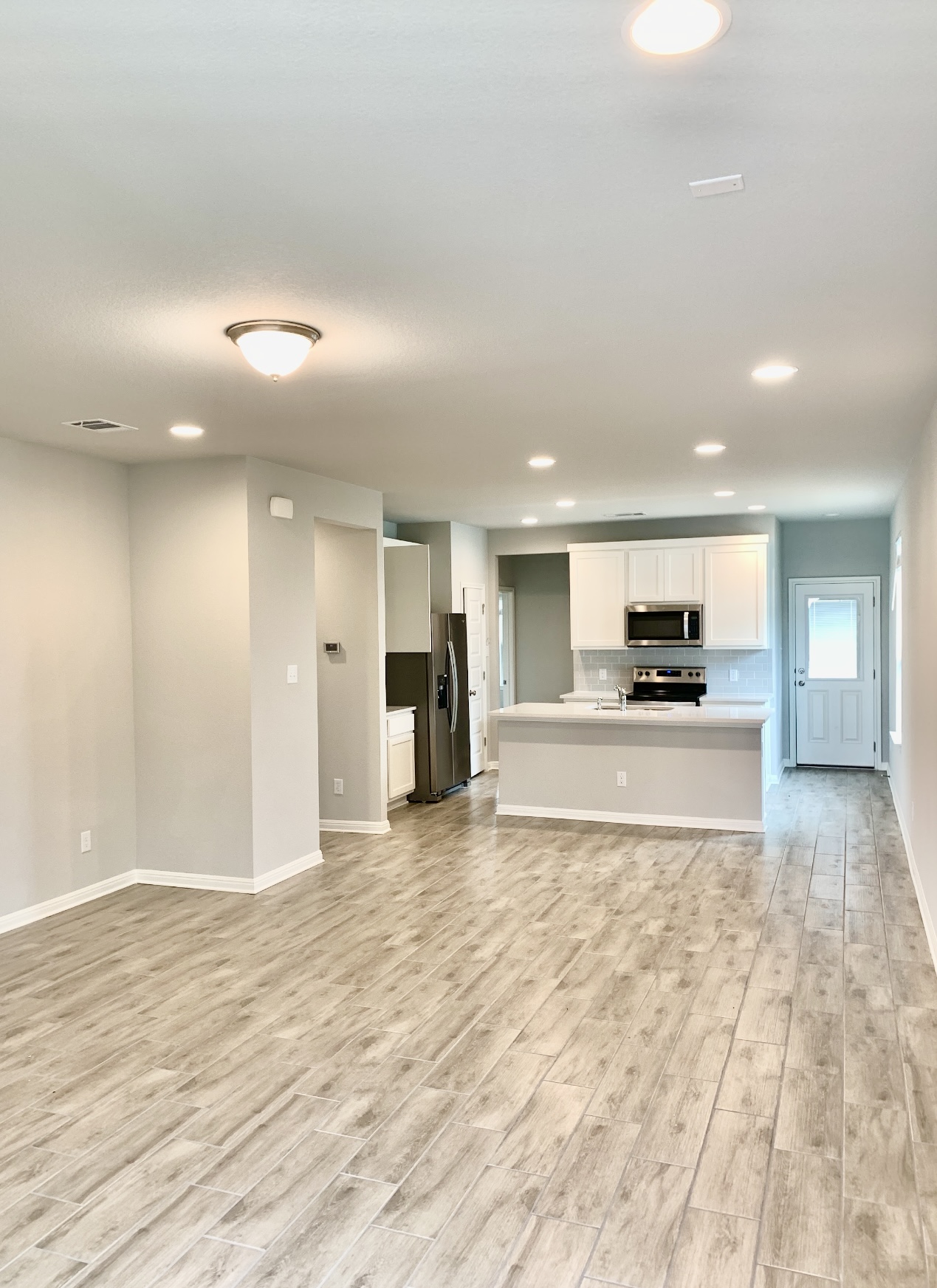 119 Wild Wind Cove Jarrell, TX 76537 - Photo 4 of 16 Unfurnished living room with light wood-style flooring, baseboards, and recessed lighting