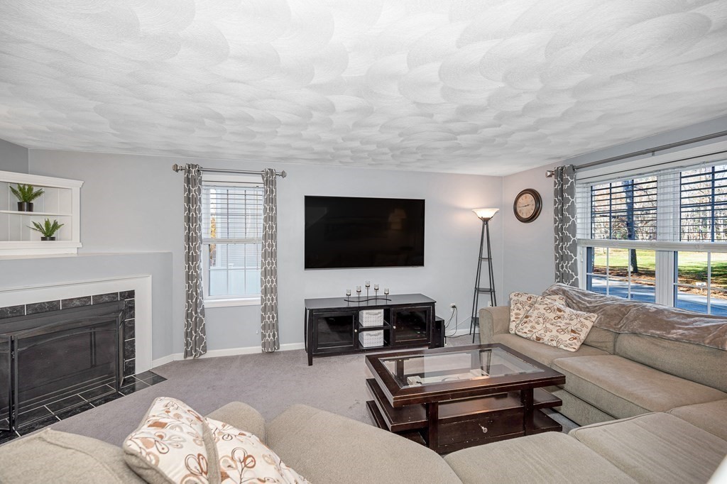46 Parham Road Tyngsboro, MA 01879 - Photo 11 of 36 a living room with furniture a flat screen tv and a fireplace