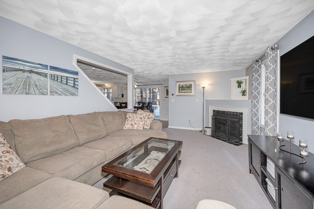 46 Parham Road Tyngsboro, MA 01879 - Photo 12 of 36 a living room with furniture a flat screen tv and a fireplace