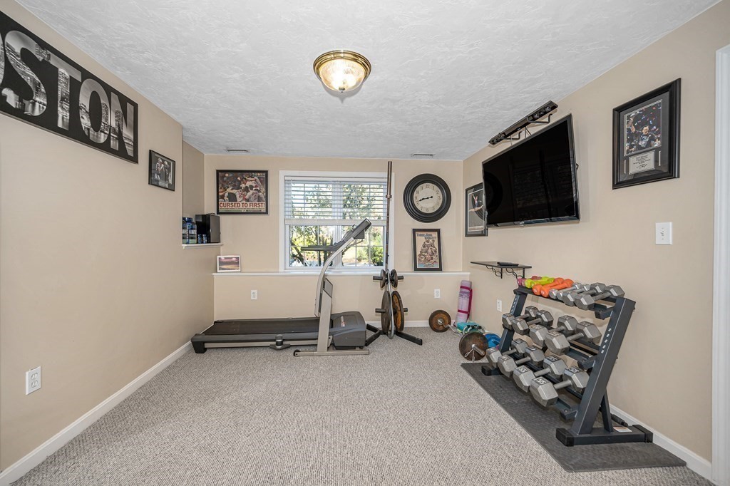 46 Parham Road Tyngsboro, MA 01879 - Photo 26 of 36 a room with furniture and a flat screen tv