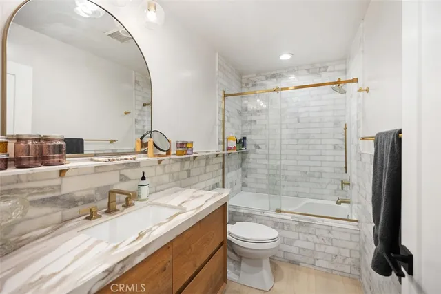 a bathroom with a granite countertop sink toilet and shower