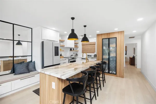 a kitchen with stainless steel appliances kitchen island granite countertop a refrigerator and a stove top oven