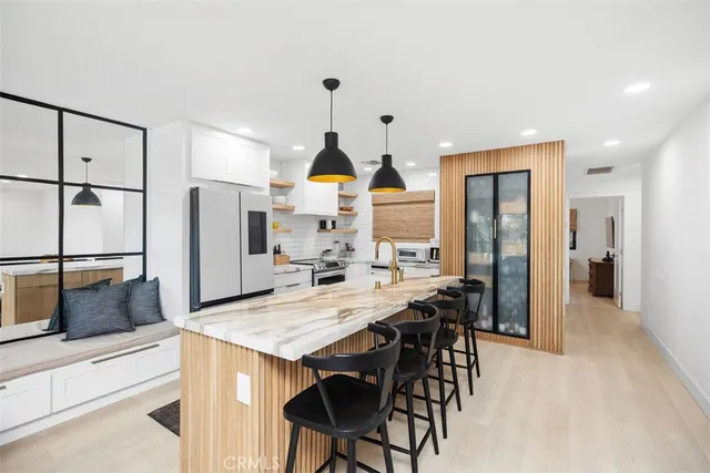 a kitchen with stainless steel appliances kitchen island granite countertop a refrigerator and a stove top oven