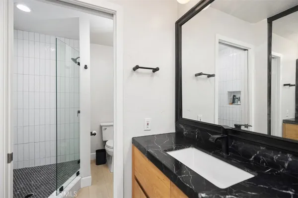 a bathroom with a granite countertop sink and a mirror