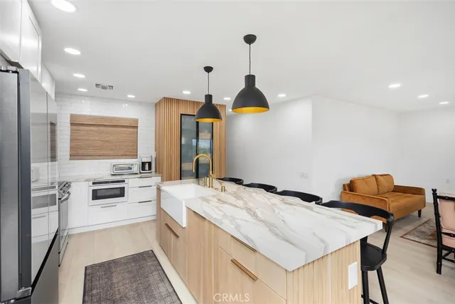 a kitchen with stainless steel appliances kitchen island granite countertop a sink and dishwasher a stove top oven with wooden floor