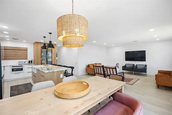 a living room with furniture a chandelier and a flat screen tv