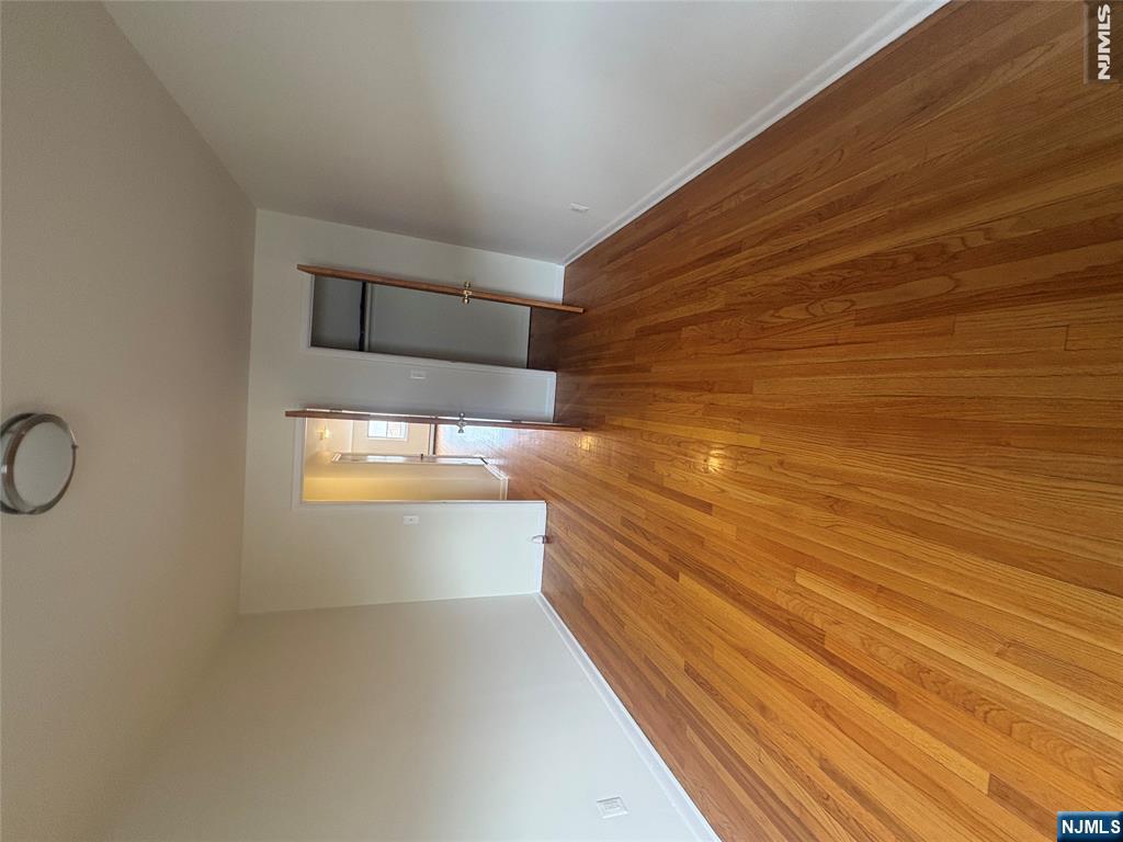 399 Walker Street, Unit 1B Fairview, NJ 07022 - Photo 8 of 11 a view of a room with wooden floor and staircase