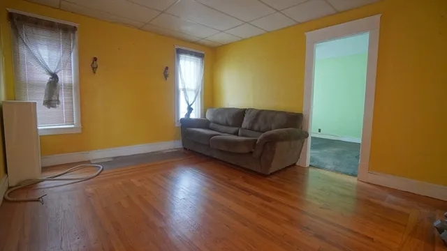 a living room with couch and a hard wood floor