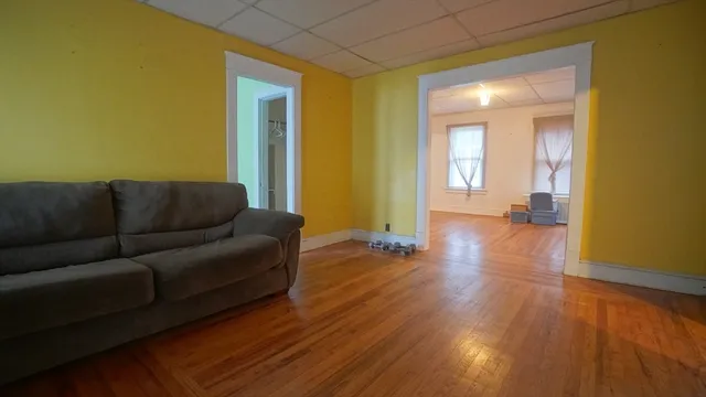 a living room with couches and painted walls next to a window