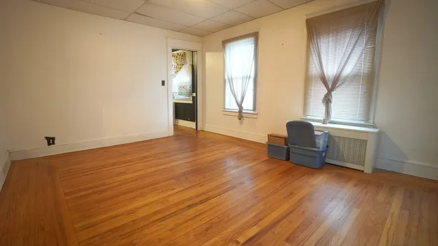a view of a livingroom with wooden floor and furniture