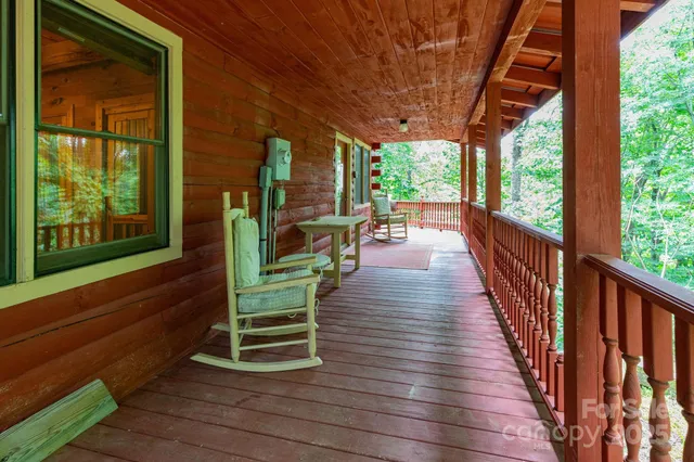 a porch with wooden floor outdoor seating and yard