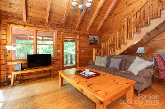 a living room with furniture a flat screen tv and a floor to ceiling window
