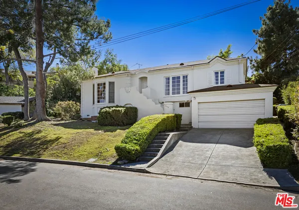 a view of a house with backyard and a tree