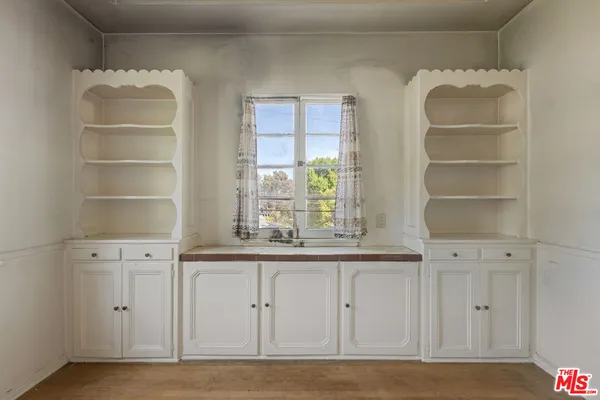 a view of a kitchen with cabinets and window