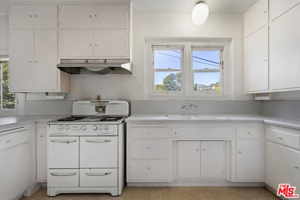 a kitchen with white cabinets and white appliances