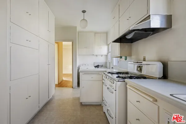 a kitchen with stainless steel appliances granite countertop a sink a stove and a refrigerator