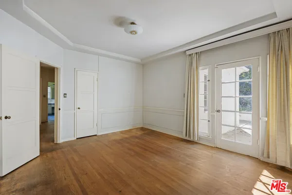 a view of an empty room with window and closet area