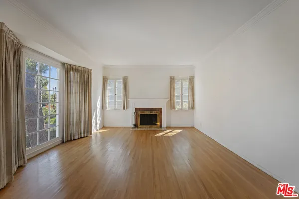 wooden floor fireplace and natural light in room
