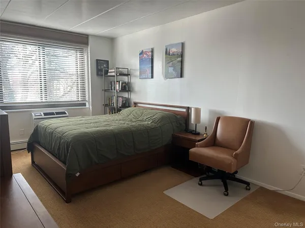 a bedroom with a bed and a chair in it