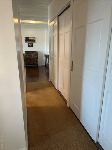 a view of a hallway to a livingroom and a livingroom with furniture