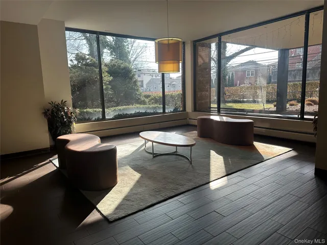 a living room with couches a coffee table and a large window with outer view