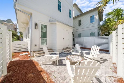 a large white kitchen with lots of counter space a sink and a large window