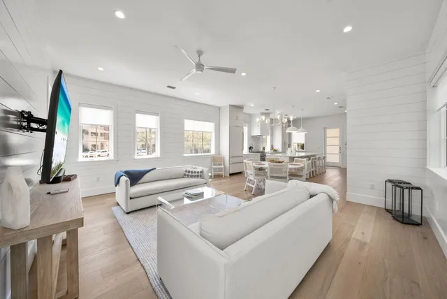 a large kitchen with a large counter top space a sink stainless steel appliances and cabinets