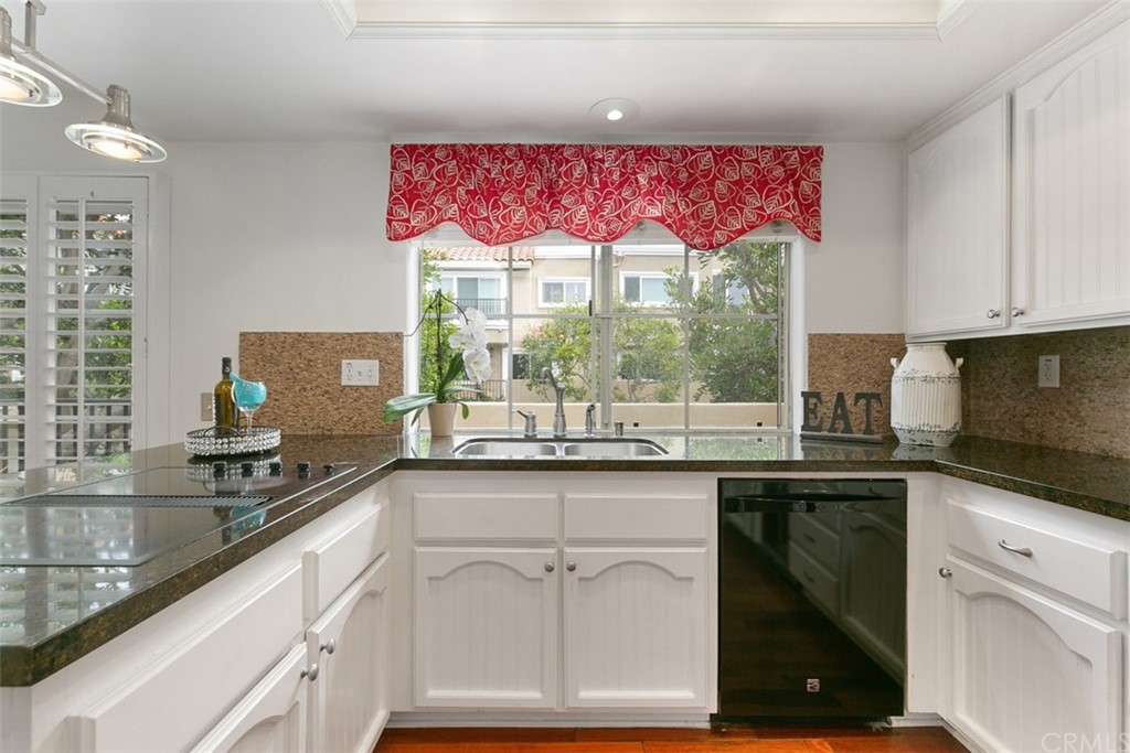 6051 Shadowbrook Circle Huntington Beach, CA 92648 - Photo 21 of 42 a kitchen with granite countertop a sink and white cabinets
