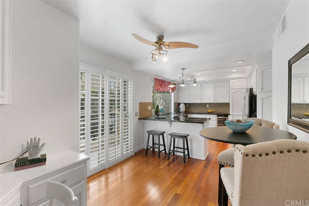 6051 Shadowbrook Circle Huntington Beach, CA 92648 - Photo 22 of 42 a kitchen with a dining table chairs and a refrigerator
