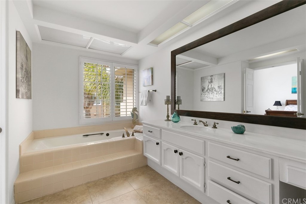 6051 Shadowbrook Circle Huntington Beach, CA 92648 - Photo 28 of 42 a bathroom with a tub a sink and mirror